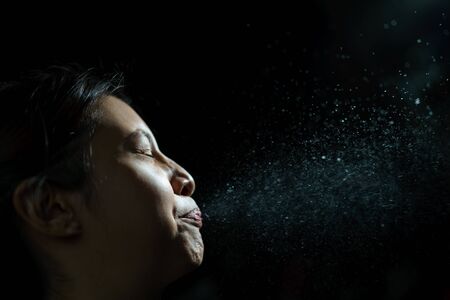 Woman coughing or sneezing. Concept of spread of the virus. Spray infectionの写真素材