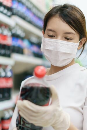 soft drink
Woman wearing surgical mask and gloves,  buying soft drink in supermarket. Panic shopping after coronavirus pandemic.の写真素材