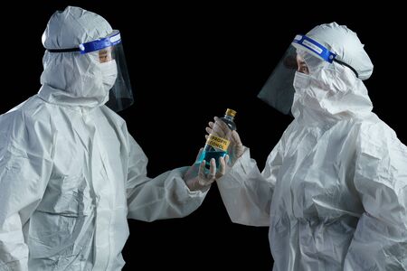 Doctor wearing ppe suit and face mask and face shield in hospital hand holding ethly alcohol Corona...