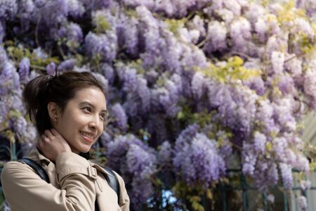 Woman with beautiful purple flower blossom vine.の写真素材
