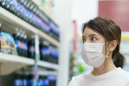 soft drinkWoman wearing surgical mask and gloves,  buying soft drink in supermarket. Panic shopping...
