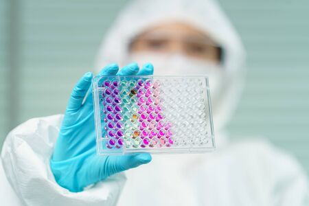 Scientist in laboratory with  biological tube for analysis and sampling of Covid-19.