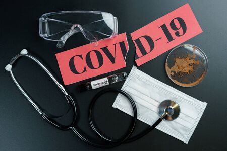 Corona virus protective equipment: Medical masks, safety glasses and stethoscope with petri dish on the table. Coronavirus, Covid-19 protection.の写真素材