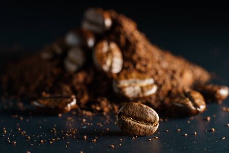 Ground coffee and coffee beans on black background.の写真素材