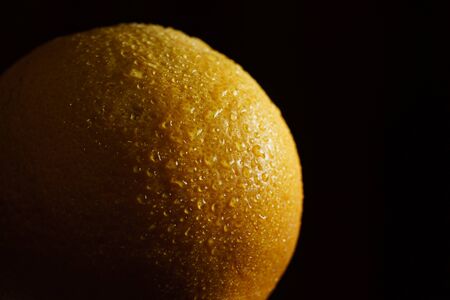 Orange fruit with drops with black background.の写真素材