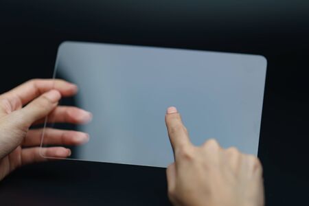 Hand holding and showing transparent tablet device. Business, technology concept.の写真素材