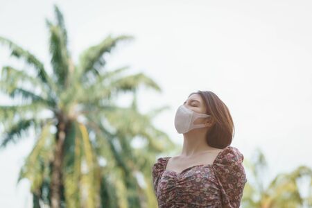 A woman wearing face mask in the park.
Corona virus or Covid-19 protection concept.の写真素材