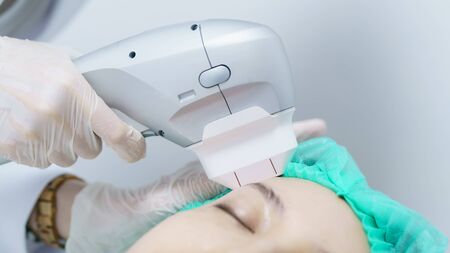 Woman getting Hifu spa treatment, girl receiving  ultra former massage face. Anti aging treatment and plastic surgery concept.の写真素材