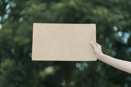 Woman's hands holding a blank placard to put the text at protesting.の写真素材