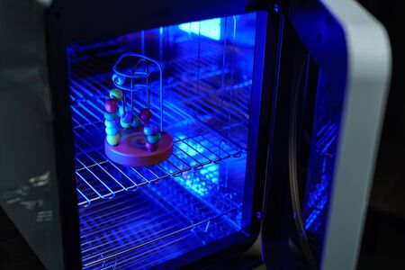 UV light sterilization of baby wooden toy to disinfection. COVID-19 prevention concept. ultra-violet...