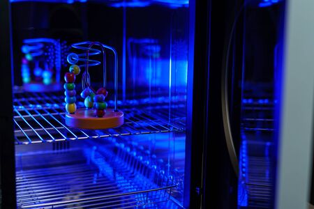 UV light sterilization of baby wooden toy to disinfection. COVID-19 prevention concept. ultra-violet sterilization and disinfection.の写真素材