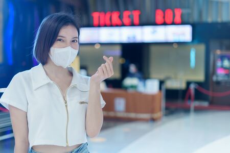 Woman wearing face mask at ticket box office, Cinema, movie theater corona virus or Covid-19 protection.の写真素材