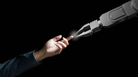 Robot arm and human hand touch like  Adam sign isolated on black background. Concept of togethernessの写真素材
