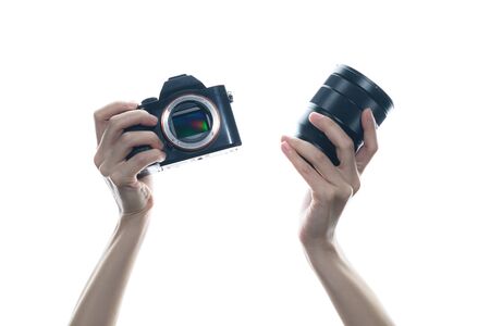 Woman hand holding camera and lens on white background.の写真素材