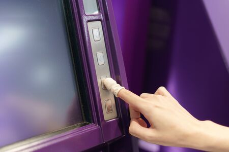 Woman wearing rubber for finger pressing a button of Automated Teller Machine( ATM )の写真素材