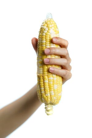 Ripe corn in condom with hand on white background. isolatedの写真素材
