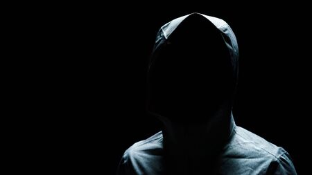 Portrait of Invisible man in the hood on black background.の写真素材