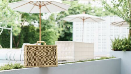 A wicker suitcase near the pool.の写真素材
