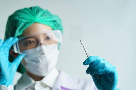 Woman doctor hold  empty glass microscope slide. copy space