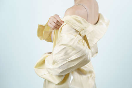 Woman takes off her light yellow shirt.の写真素材