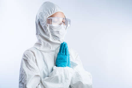 Doctor hands clasped together praying to God for hope. Coronavirus concept.の写真素材