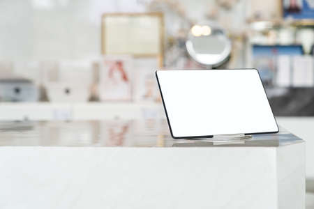 Mockup tablet with blank white screen on table.
