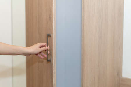 Woman hand open brown wooden drawer.の写真素材