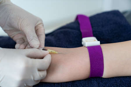 Doctor hand put intravenous(IV) injection on patient arm for drip medicine.