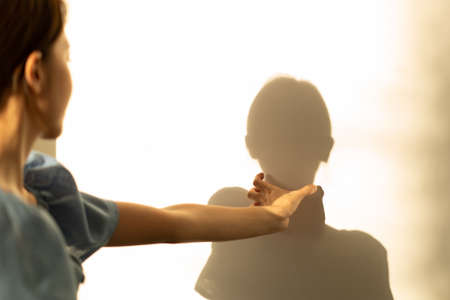 Woman is crazy, suffocating her shadow with hands squeezing neck.