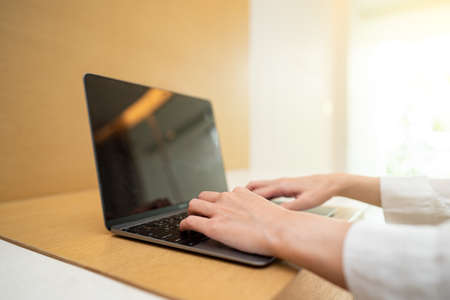 Woman working on laptop computer on wooden table. for your advertising text message.の写真素材