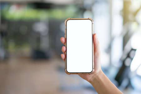Woman hand holding mobile phone with blank white screen mockup.