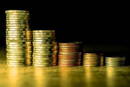 Stack of gold coins on dark background.の写真素材