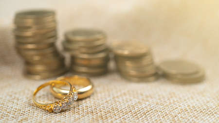 Wedding rings with stack of coins,  saving money for marry.