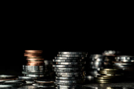 Stack of different coins on dark background.の写真素材