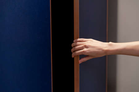 Closeup hand open wardrobe or cupboard door.