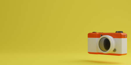 Red and white digital camera on yellow background, technology concept. 3d renderingの写真素材
