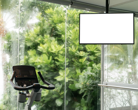 Cardio training : treadmill with white screen mockup , large windows with ocean view raining outside.の写真素材