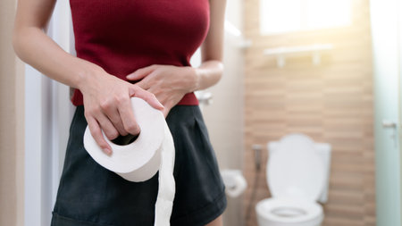 woman with toilet paper, stomachache diarrhea symptom, menstrual period cramp or food poisoning. Health care concept.の写真素材