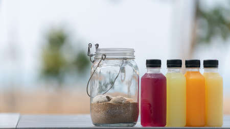 Healthy smoothies fruit and vegetable juice in bottles with sand in bottleの写真素材