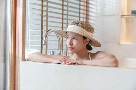 woman wearing bikini and straw hat  relaxing in hot tub. spa treatmentsの写真素材