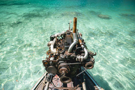 Old Machine of Fishing boat at the clear blue sea water in Thailand.の写真素材
