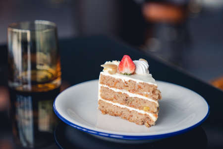 Carrot cake with strawberries topping on table.の写真素材