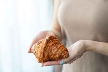 Woman hand serving baked crispy croissants.の写真素材
