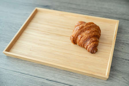 Serving baked crispy croissants on wooden tray.の写真素材