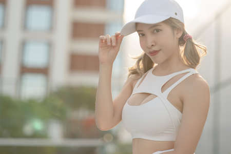 Woman tennis player in a white skirt resting on a tennis court.の写真素材