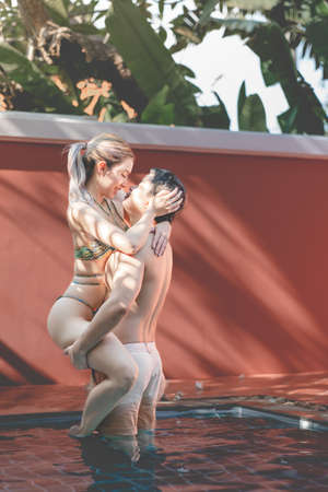 Couple in love, Man carrying woman in  swimming pool.の写真素材