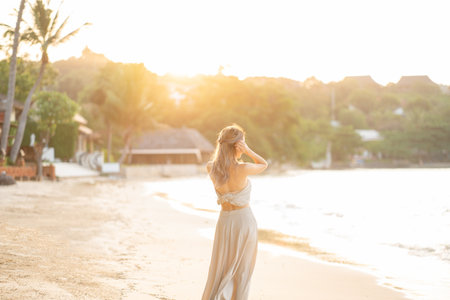 Woman in glamorous long skirt on wind, posing on the beach. Summer Holiday.の写真素材