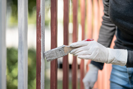 Hand holds a paintbrush and paints the fence, Repair.の写真素材
