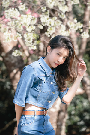 Woman with cherry blossoms or sakura flower blooming in the parkの写真素材