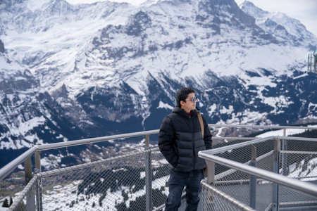 Grindelwald first, Switzerland 
Man on First Cliff Walk viewing platform on the First mountain in Grindelwald with Alpine views.の写真素材